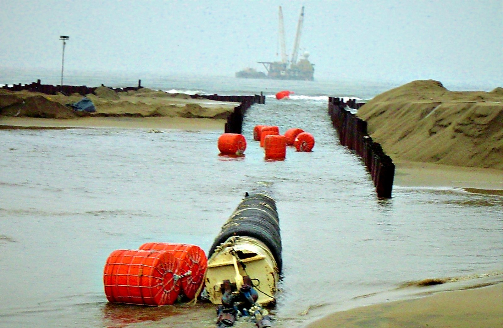Shore approach cofferdam with buoyancy floats and lay barge offshore