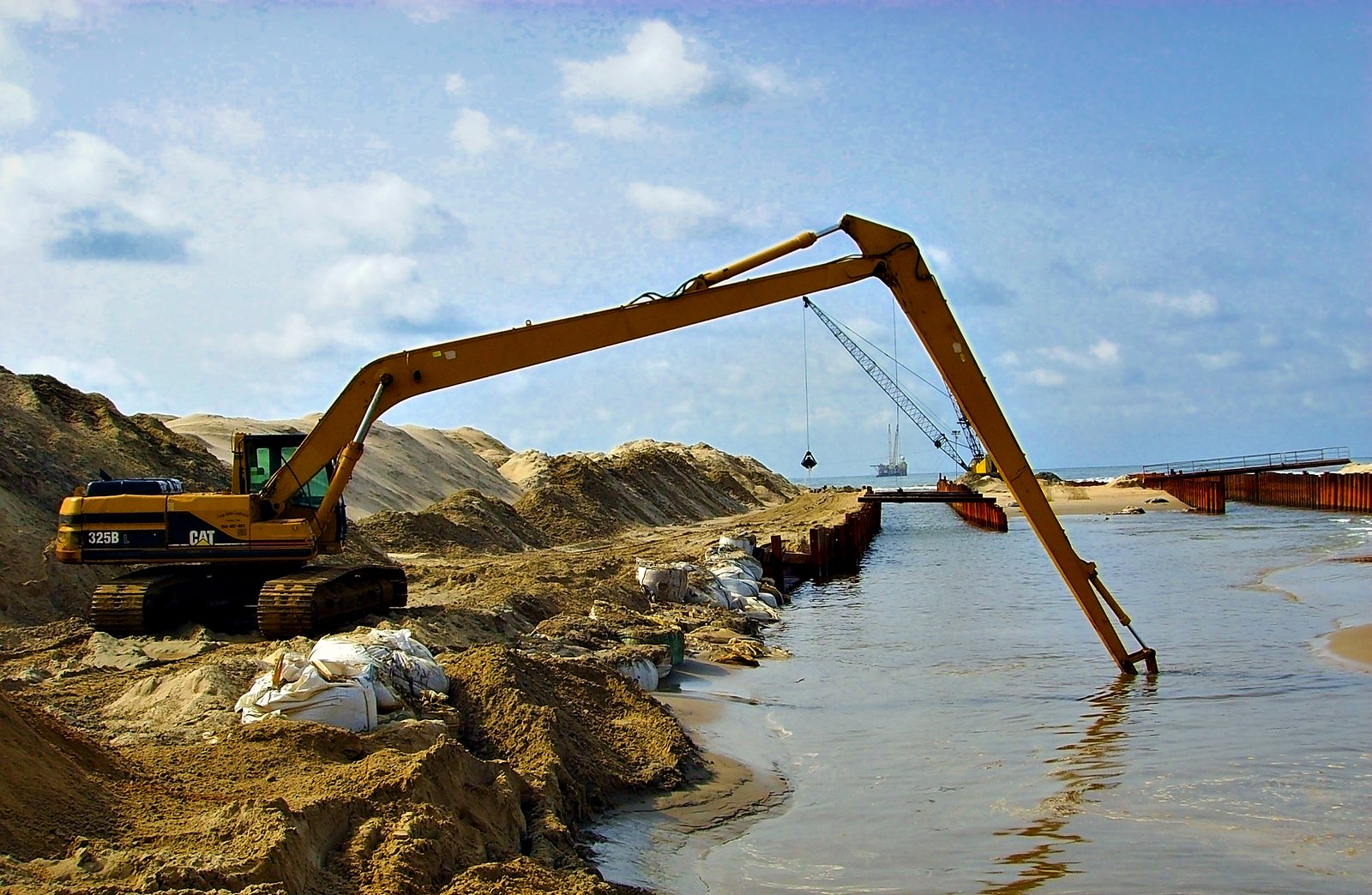 Long-reach excavator pre-trenching inside the flooded cofferdam