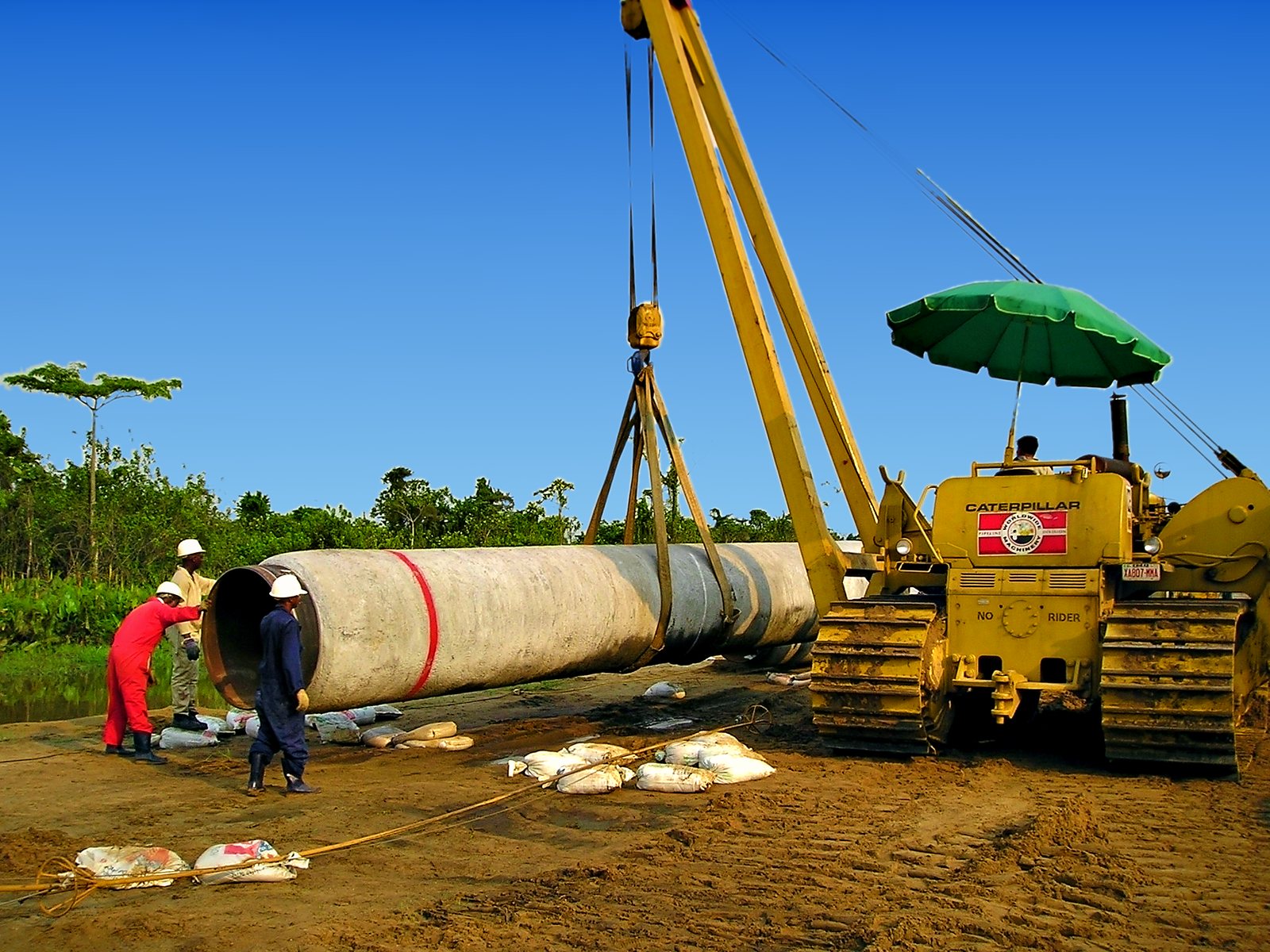 Sideboom stringing a coated pipe joint along the right-of-way