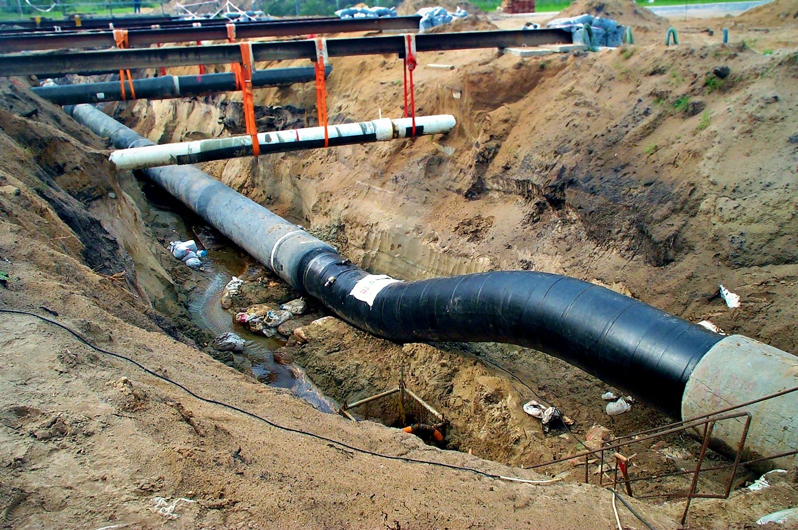 Coated pipe with a field bend in the trench