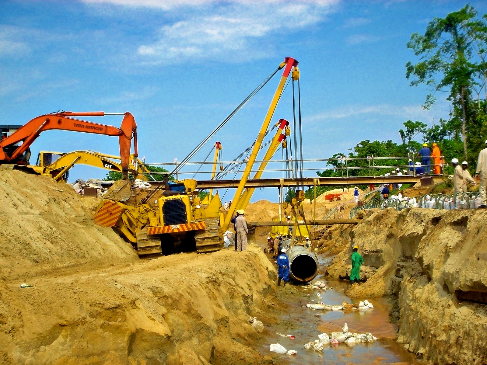 Sidebooms and excavator at a pipeline crossing
